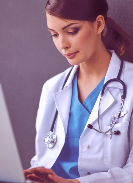Nurse holding folder and taking notes - sitting on grey background — Stock Photo, Image