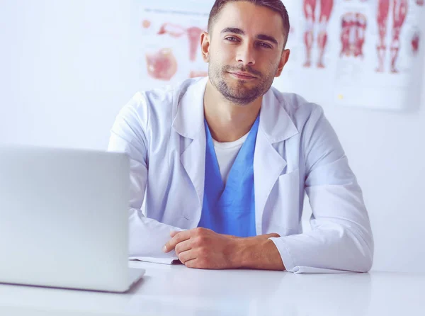 Porträt eines männlichen Arztes mit Laptop am Schreibtisch in der Arztpraxis — Stockfoto