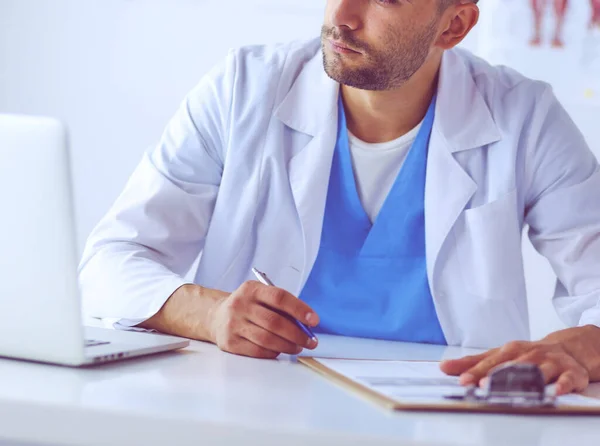 Porträt eines männlichen Arztes mit Laptop am Schreibtisch in der Arztpraxis — Stockfoto