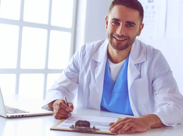 Porträt eines männlichen Arztes mit Laptop am Schreibtisch in der Medizin — Stockfoto