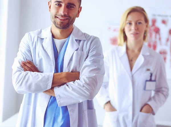 Jonge en zelfverzekerde artsen portret staan in het medisch kantoor — Stockfoto