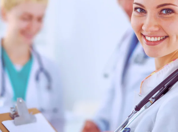 Приваблива жінка-лікар з текою перед медичною групою — стокове фото