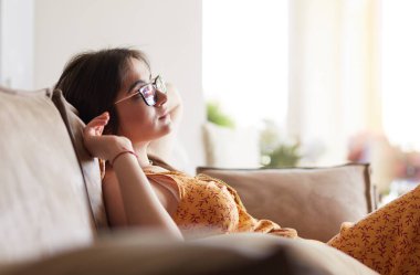 Evdeki modern bir kanepede oturan rahat kadın.