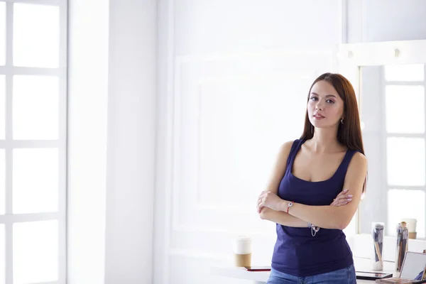 Mujer de pie con las manos dobladas en su salón —  Fotos de Stock