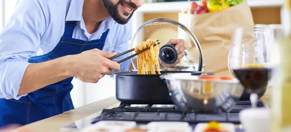 Uomo che prepara cibo delizioso e sano nella cucina di casa — Foto Stock