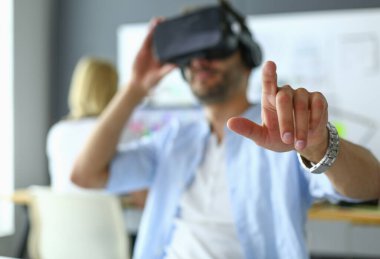 Genç erkek yazılım programcısı ofiste üç boyutlu sanal gerçeklik gözlükleriyle yeni bir uygulama test ediyor..