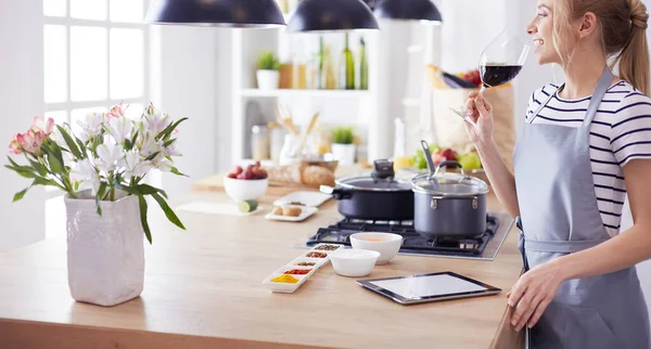 Mooie vrouw die thuis wat wijn drinkt in de keuken — Stockfoto