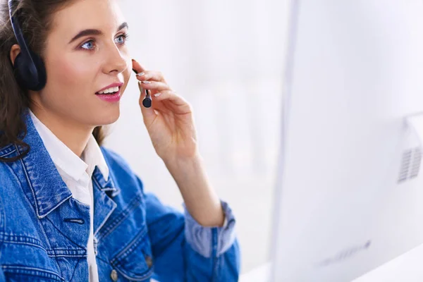 Retrato de una hermosa mujer de negocios trabajando en su escritorio con auriculares y portátil —  Fotos de Stock