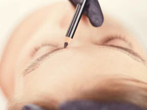 Kosmetikerin schminkt die Augenbrauen dauerhaft — Stockfoto