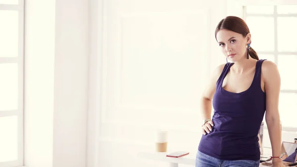 Kvinna stående med händerna vikta i hennes salong — Stockfoto