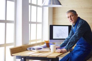 Ofisteki çizim masasında çalışan mimar