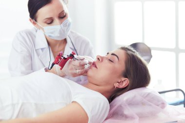 Kırmızı dudaklı genç bir kız kalıcı makyaj, mikro pigmentasyon