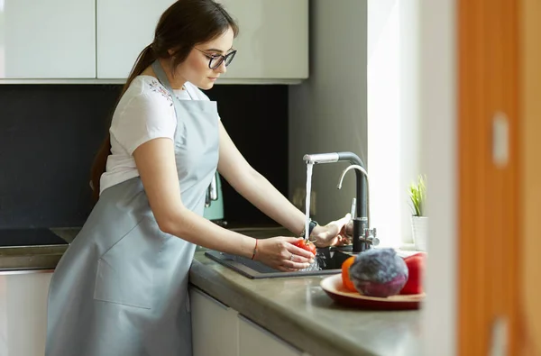 Vrouw wassen tomaten in keuken gootsteen close up — Stockfoto