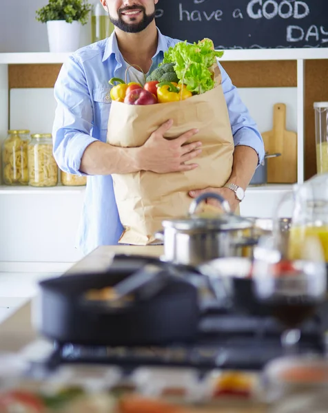 家のキッチンでおいしいと健康食品を準備する男 — ストック写真