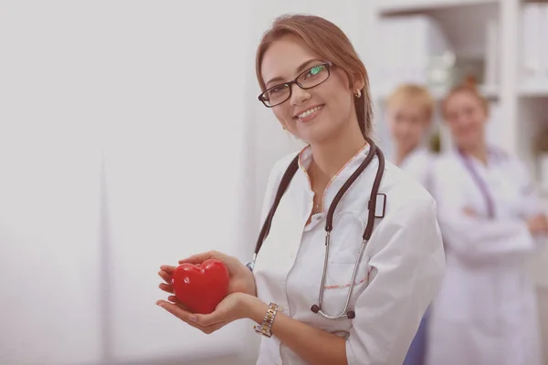 Женщина-врач держит сердце, изолированное на белом фоне — стоковое фото