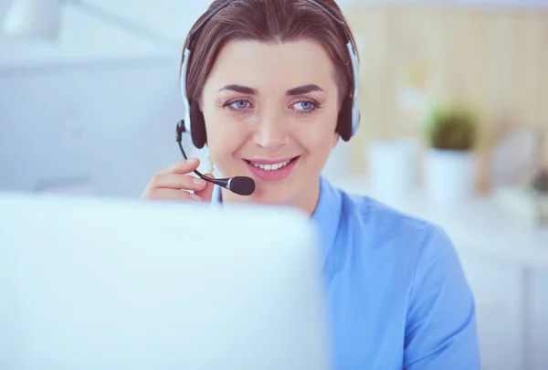 Ernstige mooie jonge vrouw die werkt als support telefoon operator met headset in het kantoor — Stockfoto