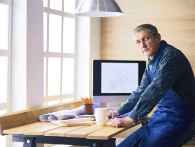 Ofisteki çizim masasında çalışan mimar