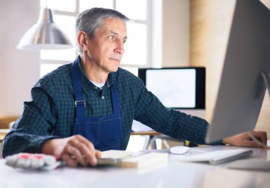 Ofisteki çizim masasında çalışan mimar