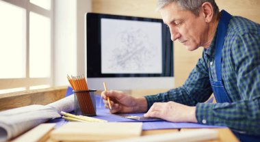 Ofisteki çizim masasında çalışan mimar