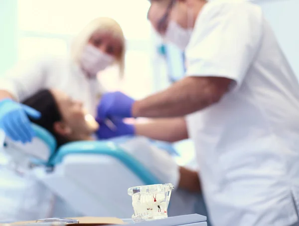 Dokter gigi dan asistennya melakukan pemeriksaan menyeluruh — Stok Foto