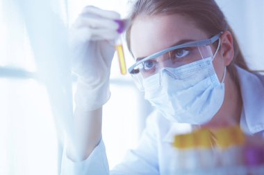 Modern laboratuvar veya hastanede plastik tıbbi tüplerle çalışan araştırmacı, doktor, bilim adamı veya laboratuvar asistanı.