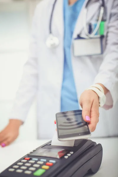 Doktor ödeme terminalini elinde tutuyor. Sağlık hizmetlerinin parasını ödüyorum. Doktor. — Stok fotoğraf