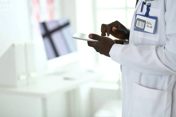 Male black doctor worker with tablet computer standing in hospital