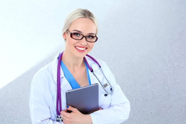 Kobieta lekarz za pomocą tabletki cyfrowej i stojąc na białym tle. Lekarki. — Zdjęcie stockowe
