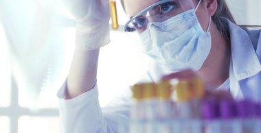 Hastanedeki kan örneğini analiz eden güzel bir kadın laboratuvar asistanı portresi.