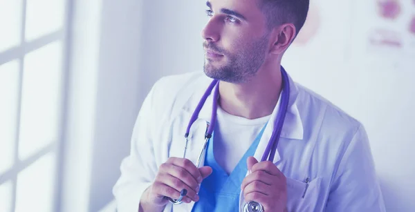 Genç ve kendinden emin erkek doktor portresi tıp ofisinde duruyor.. — Stok fotoğraf