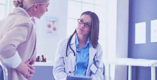 Doktorn och patienten diskuterar något när de sitter vid bordet. Medicin och hälsovård — Stockfoto