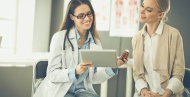 Doktor ve hasta masada otururken bir şey tartışıyorlar. İlaç ve sağlık hizmetleri kavramı