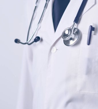 Genç ve kendinden emin erkek doktor portresi tıp ofisinde duruyor.