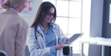 Doktor ve hasta masada otururken bir şey tartışıyorlar. İlaç ve sağlık hizmetleri kavramı