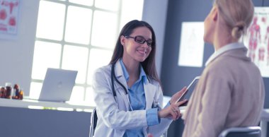 Doktor ve hasta masada otururken bir şey tartışıyorlar. İlaç ve sağlık hizmetleri kavramı