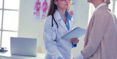 Doktor ve hasta masada otururken bir şey tartışıyorlar. İlaç ve sağlık hizmetleri kavramı