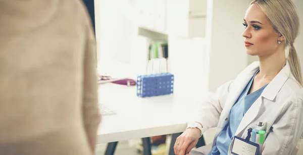 Dottore e paziente discutono di qualcosa mentre sono seduti al tavolo. Medicina e concetto di assistenza sanitaria. Medico e paziente — Foto Stock