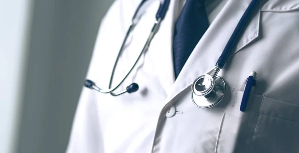 Retrato médico masculino joven y confiado de pie en el consultorio médico —  Fotos de Stock