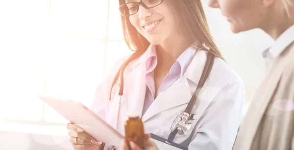 Doctor y paciente discutiendo algo mientras están sentados en la mesa. Concepto de medicina y salud — Foto de Stock