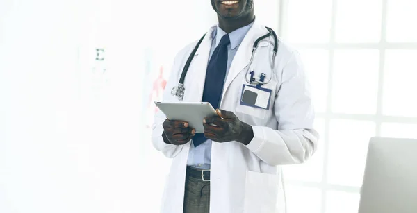 Male black doctor worker with tablet computer standing in hospital