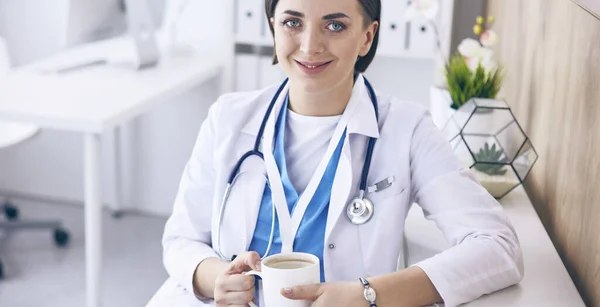 Portrait of professional female doctor holding cup of coffee — Stock Photo, Image