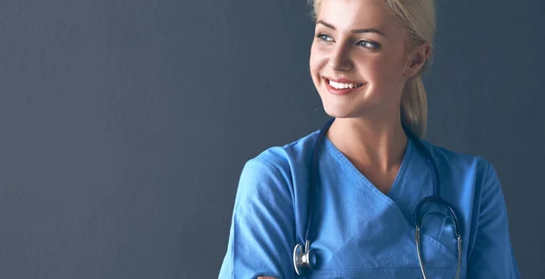 Jeune médecin femme avec stéthoscope isolé sur fond gris — Photo