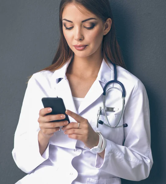 Mujer joven médico sentado con su teléfono — Foto de Stock