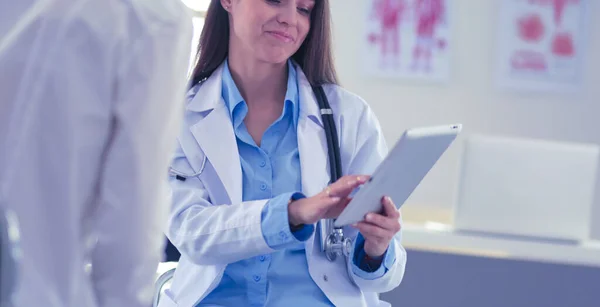 Dokter en patiënt bespreken iets terwijl ze aan tafel zitten. Begrip "geneeskunde en gezondheidszorg" — Stockfoto