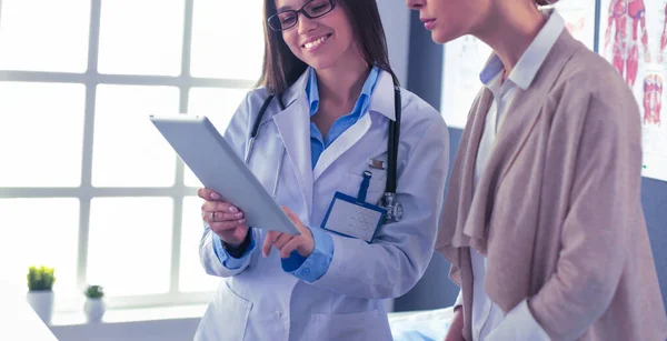 Dokter en patiënt bespreken iets terwijl ze aan tafel zitten. Begrip "geneeskunde en gezondheidszorg" — Stockfoto