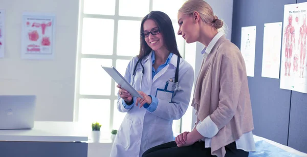 Dottore e paziente discutono di qualcosa mentre sono seduti al tavolo. Medicina e concetto di assistenza sanitaria — Foto Stock