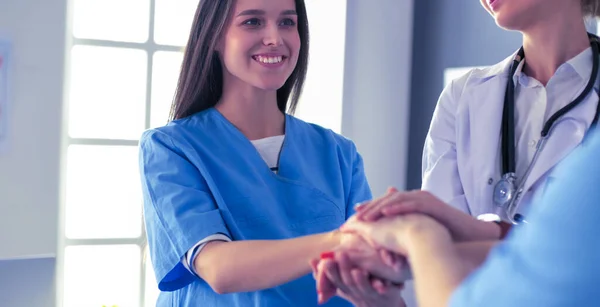 Artsen en verpleegkundigen in een medisch team stapelen handen — Stockfoto