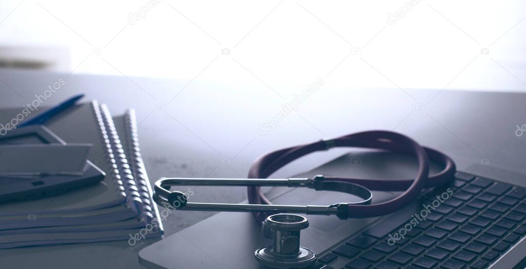 Workplace of doctor with laptop and stethoscope and notebook