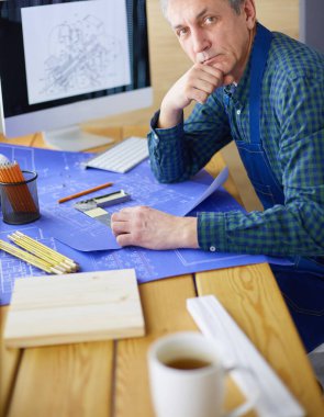 Ofisteki çizim masasında çalışan mimar