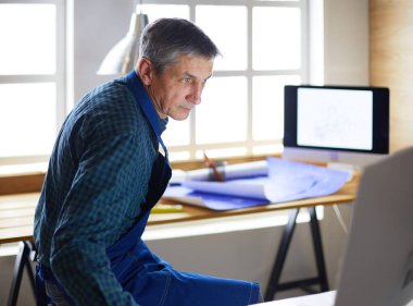 Ofisteki çizim masasında çalışan mimar